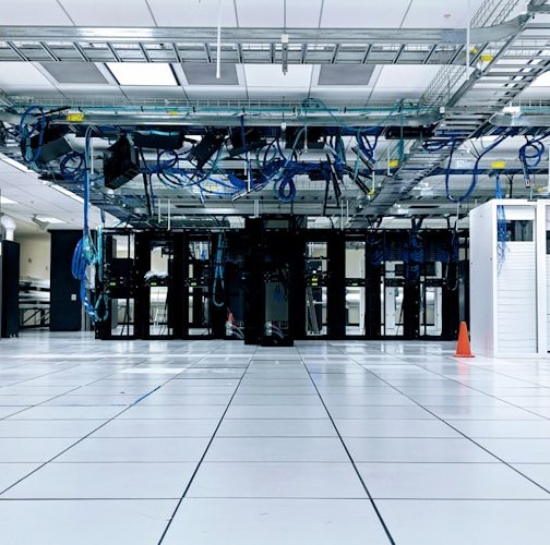 Aisle between server racks with cabling organized in overhead trays