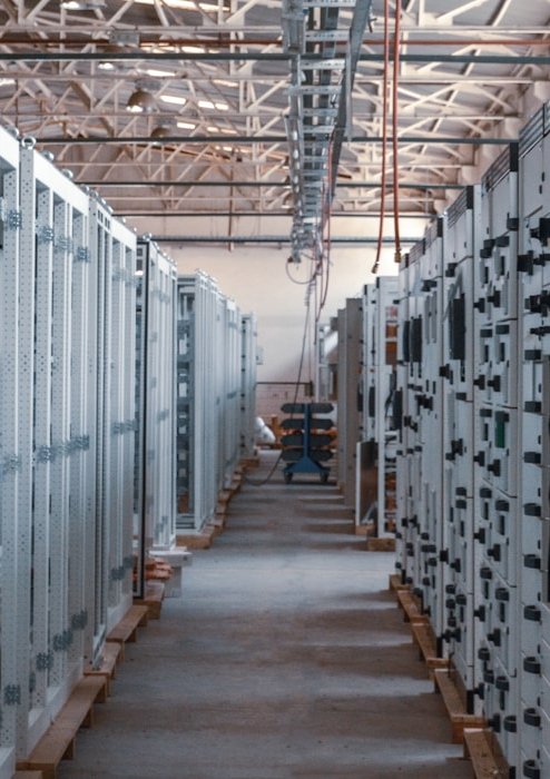 Corridor of electrical panels in a data center infrastructure room