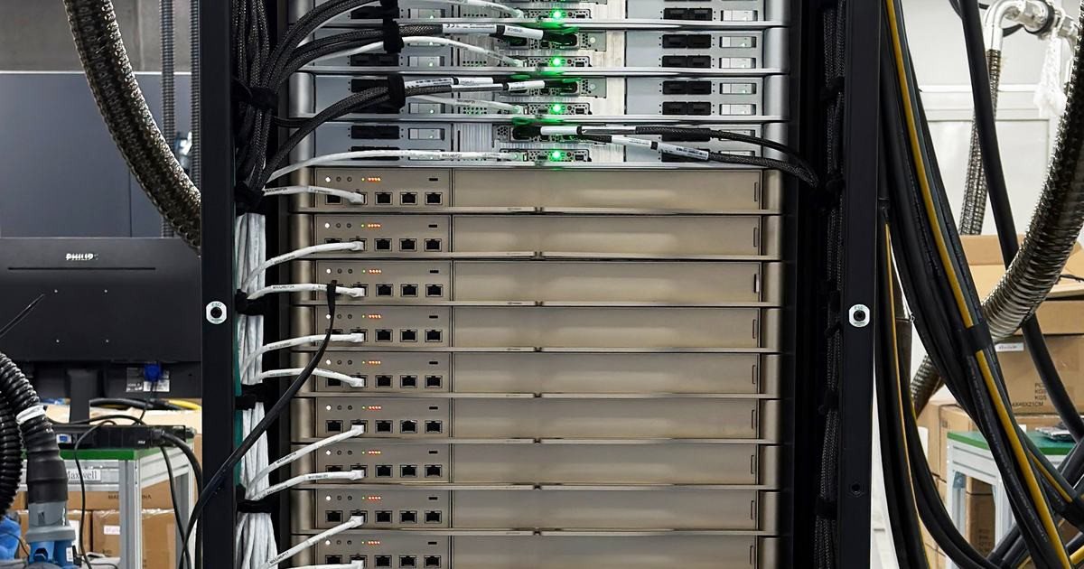 Detalhe de módulos, cabos de rede e indicadores luminosos em rack de validação